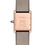 Back view of the Tank Louis Cartier rose gold watch with inscriptions—Cartier, mécanique, SWISS MADE, Au 750—a leather strap, and a crown adorned with a blue sapphire cabochon.