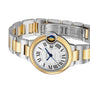 A Ballon Bleu de Cartier wristwatch by Cartier, featuring a two-tone gold and silver design, round face with Roman numerals, blue sapphire cabochon crown, and open metal bracelet.