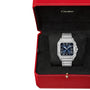 A Cartier Santos de Cartier wristwatch featuring a blue face and silver case is shown in an open red Cartier box with black lining.