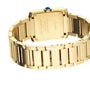Close-up of the back of a Cartier Tank Française wristwatch, highlighting engraved details and the blue gemstone crown. The yellow gold bracelet contrasts elegantly against a white background.