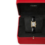 The Cartier Tank Louis Cartier watch, featuring a rectangular yellow gold case and a black alligator leather strap, is presented on a black cushion inside a red Cartier box.