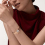 A person in a sleeveless burgundy top wears a rose gold Cartier Panthère de Cartier Small Model watch with a square face on their left wrist.