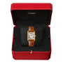 A Cartier Tank Louis Cartier watch with a brown leather strap is presented in an open red box lined with black velvet, highlighting its timeless 18K yellow gold design.