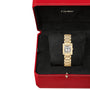 A Cartier Tank Française wristwatch with a rectangular face is displayed on a black cushion inside an open red Cartier box.