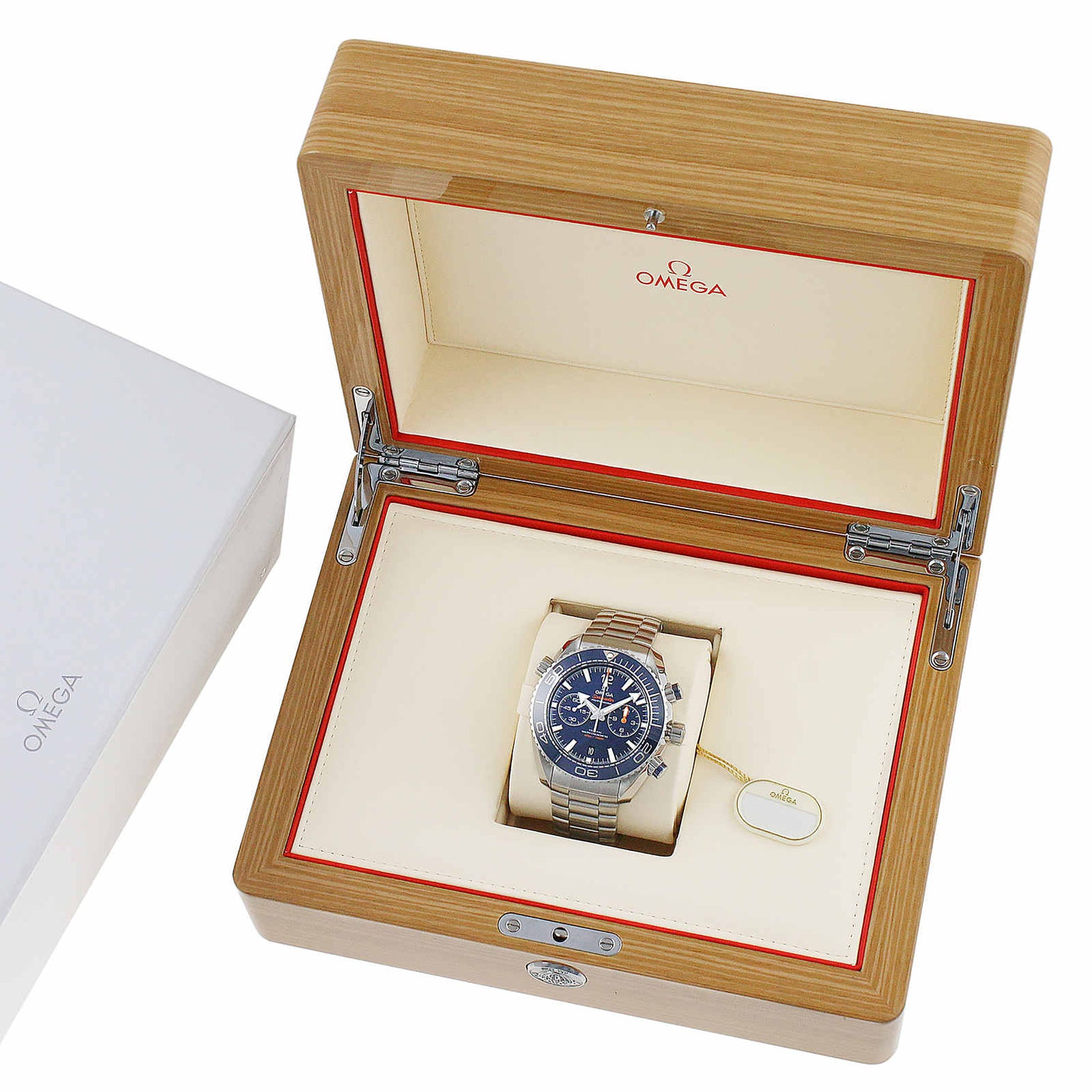 An OMEGA Seamaster Planet Ocean 600M stainless steel wristwatch with a black dial is presented in an open wooden box with a cream interior and OMEGA branding, reflecting the iconic Seamaster heritage.