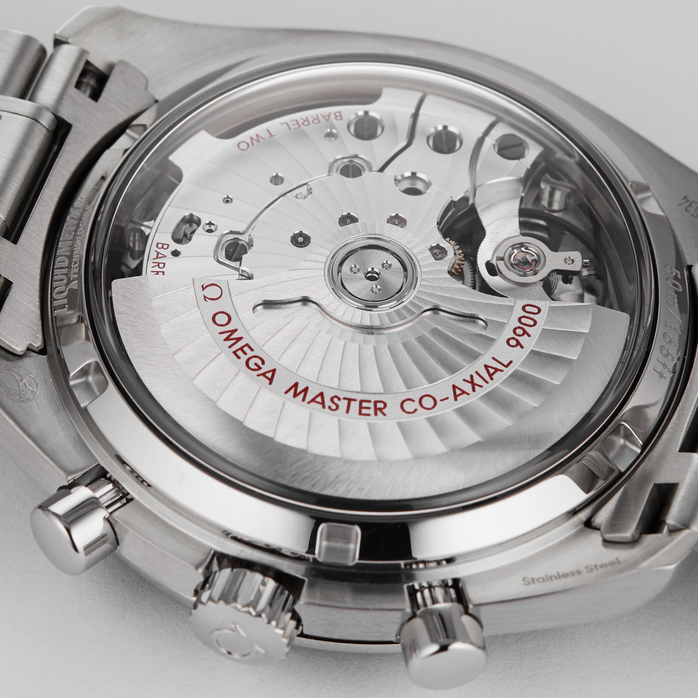 Close-up of the transparent case back of the OMEGA Speedmaster Racing, revealing the Master Chronometer-certified mechanical movement with visible gears and Omega Master Co-Axial 9900 labeling.