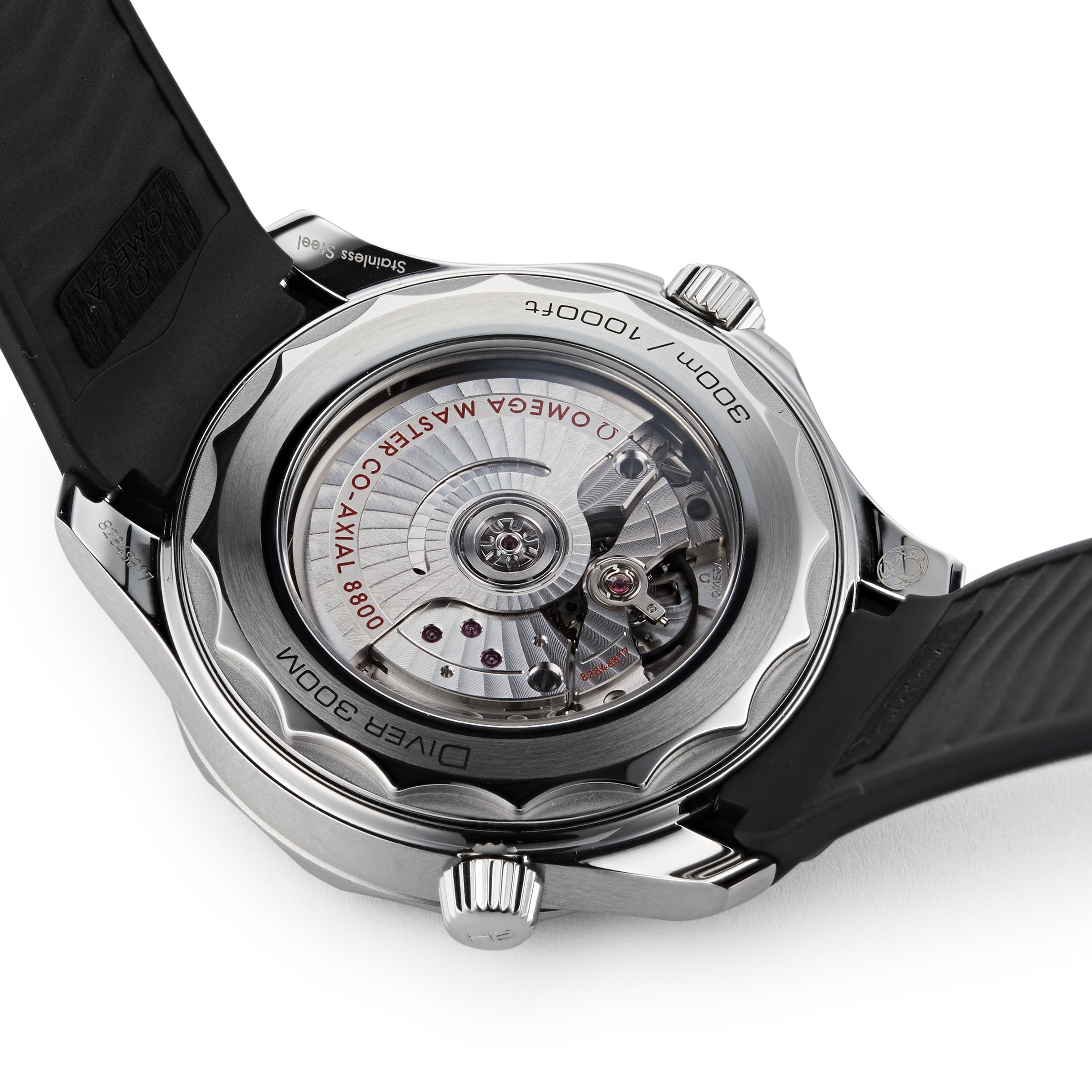 Close-up of the back of an OMEGA Seamaster Diver 300M watch, featuring the exposed mechanical movement, engravings, and a black rubber strap.