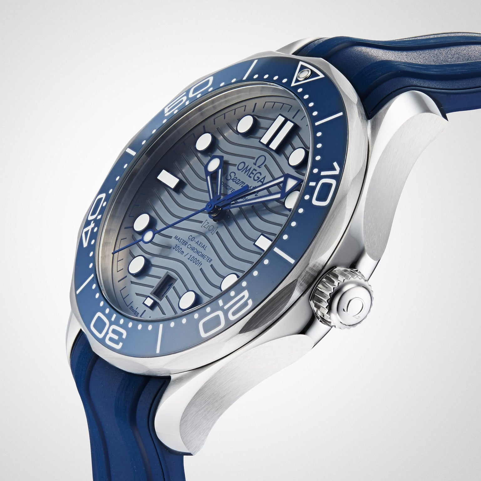 A close-up of the OMEGA Seamaster Diver 300M, featuring a wavy blue dial, luminous hour markers, and a blue rubber strap.