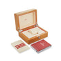 An open wooden OMEGA box reveals a padded interior, ideal for your Seamaster Diver 300M. Next to it sits a white card holder and the iconic red OMEGA instruction booklet.