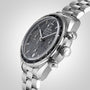 A close-up of an OMEGA Speedmaster 38 in stainless steel, featuring a black dial with three subdials, date window, tachymeter bezel, and metal bracelet.