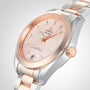 A close-up of an OMEGA Seamaster Aqua Terra 150M wristwatch with a rose gold and silver band, a rose gold bezel, and a textured pink dial adorned with diamond hour markers.