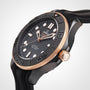 Close-up of an OMEGA Seamaster Diver 300M wristwatch with black dial, gold accents, black bezel, and rubber strap, featuring the OMEGA Calibre 8806 movement, captured against a light background.