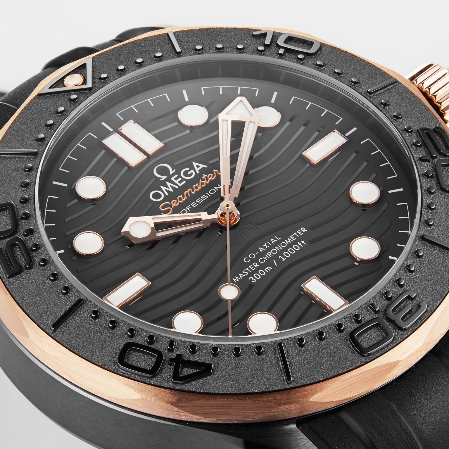 Close-up of the OMEGA Seamaster Diver 300M featuring a black wavy dial, gold accents, bold hour markers, and a numbered black bezel. Powered by the precise OMEGA Calibre 8806 and inspired by the iconic James Bond watch.