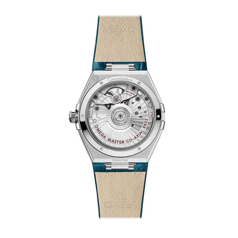 The back of the OMEGA Constellation shows its exposed Co-Axial Master Chronometer Calibre 8802 and Omega Master Co-Axial text, paired with a beige and teal leather strap.