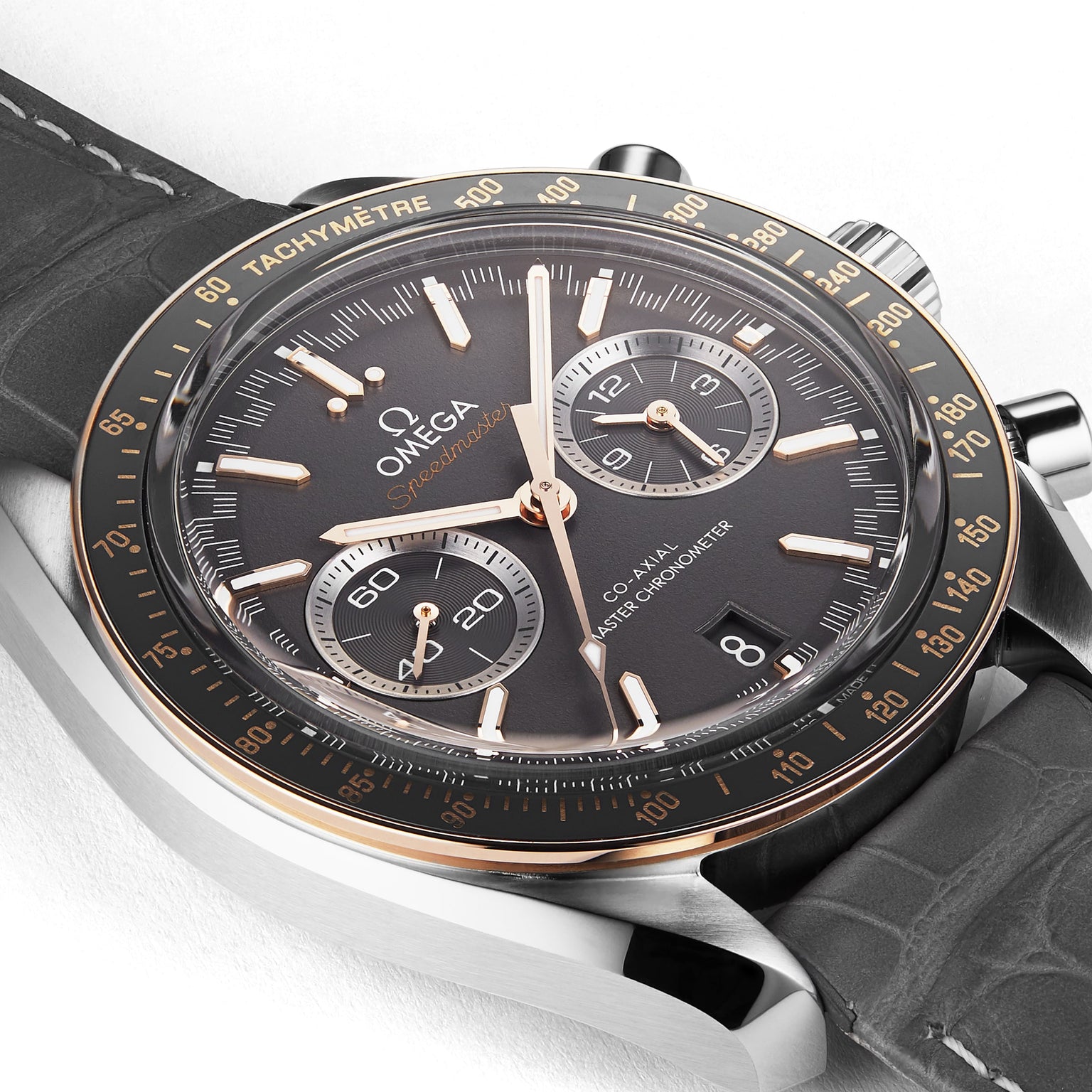 OMEGA Speedmaster Racing wristwatch featuring a black dial, gold accents, and a black leather strap shown on a white background.