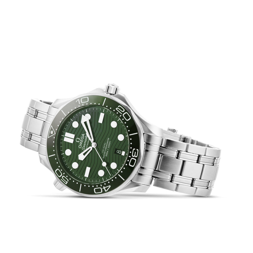 An OMEGA Seamaster Diver 300M wristwatch with a silver case, green dial, white hour markers, and stainless steel band is displayed resting on its side.