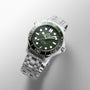 OMEGA Seamaster Diver 300M wristwatch in silver, with a green bezel and dial, white markers, and a stainless steel bracelet, shown on a light textured backdrop.