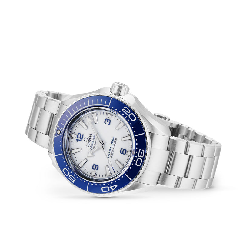 The OMEGA Seamaster Planet Ocean 6000M, made from O-MEGASTEEL, features a white dial, silver hour markers, and a blue bezel. Shown angled on white, it showcases water resistance inspired by saturation divers watches.