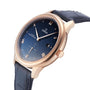 An OMEGA De Ville Prestige wristwatch with a blue leather strap and dial, Roman numerals, and date at 3 o’clock is shown angled on a white background. Highlights the renowned Omega Master Co-Axial 8802 movement.