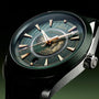 Close-up of the OMEGA Seamaster Aqua Terra 150M watch featuring a green dial, gold hands, central world map detail, and city names around the face.