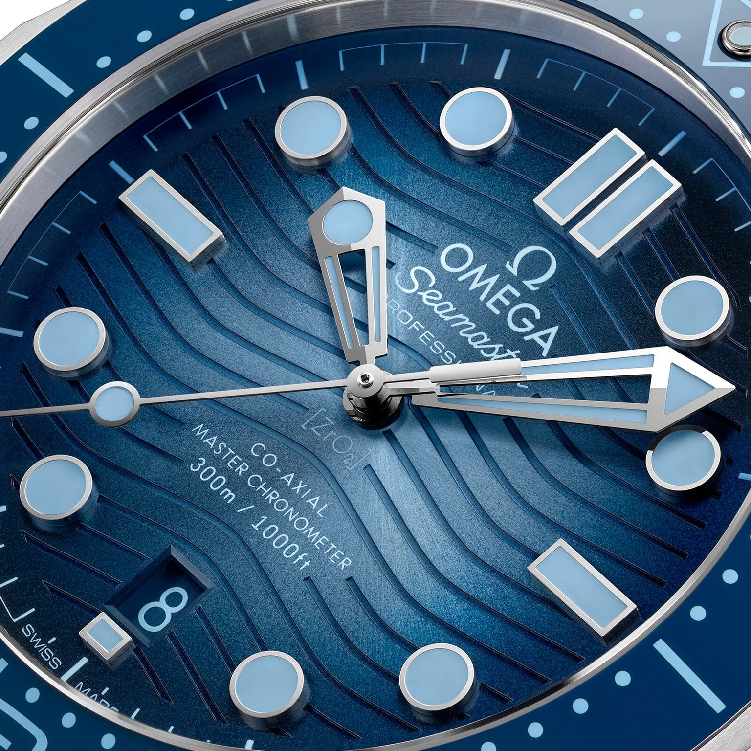 Close-up of the OMEGA Seamaster Diver 300M Summer Blue watch, featuring its blue wavy Master Chronometer dial, hands, indices, and a date window at 6 oclock.