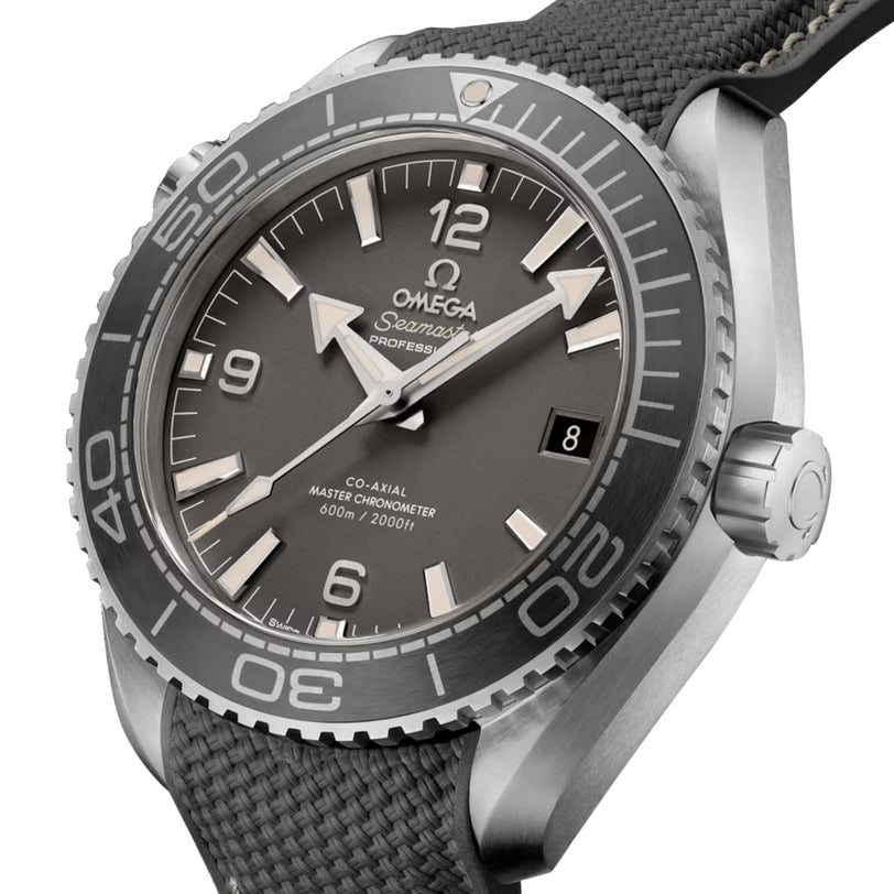 A close-up of the OMEGA Seamaster Planet Ocean 600M dive watch with a gray dial, bold white hour markers, and a textured black strap emphasizes its Co-Axial Master Chronometer precision.