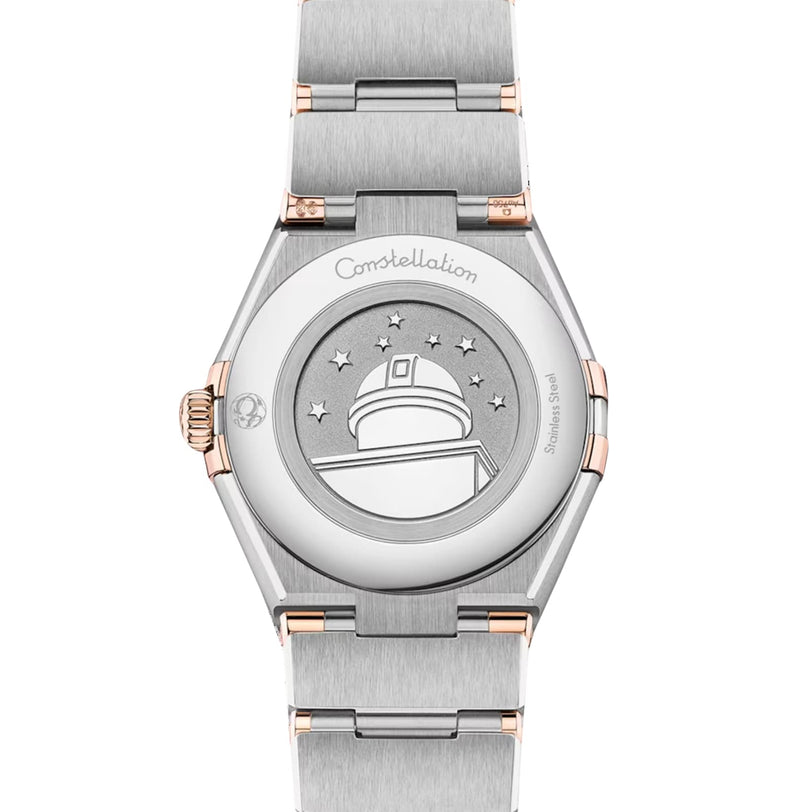 Back view of the OMEGA Constellation wristwatch featuring stainless steel and 18K Sedna Gold, with an engraved observatory, stars, and Constellation inscribed on the case back.
