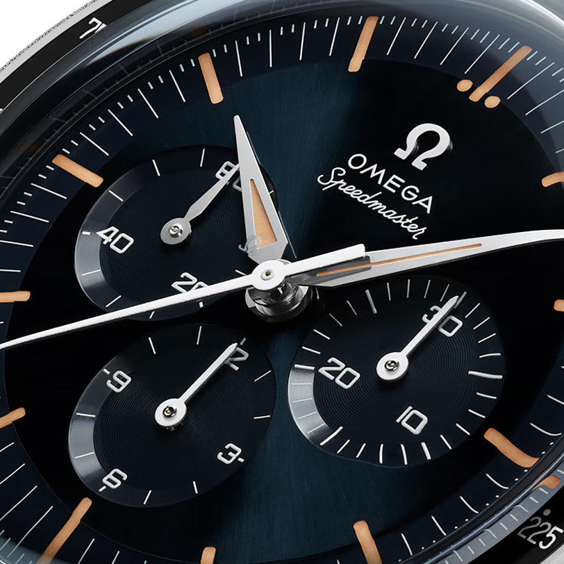 Close-up of the OMEGA Speedmaster First OMEGA in Space watch face, showcasing three subdials, orange hour markers, a tachymeter scale, and sleek silver hands.