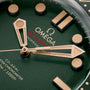 Close-up of a green OMEGA Seamaster Diver 300M watch face in 9K Bronze Gold, featuring gold hands and hour markers, partial logo, and the Co-Axial Master Chronometer model name.