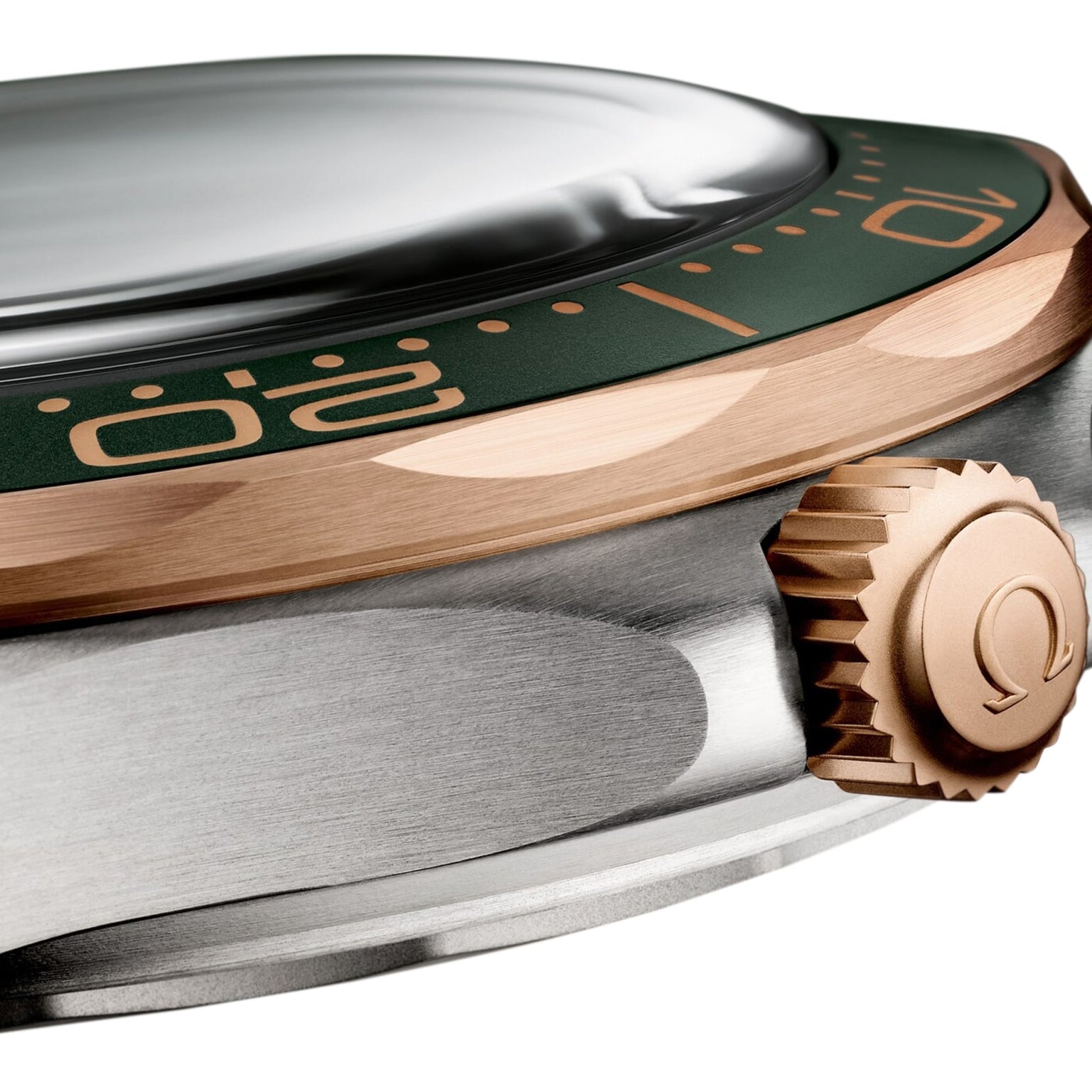 Close-up of the OMEGA Seamaster Diver 300M in 9K Bronze Gold, featuring a green bezel with gold numerals, gold crown with OMEGA logo, brushed silver case, and powered by an OMEGA Co-Axial Master Chronometer movement.