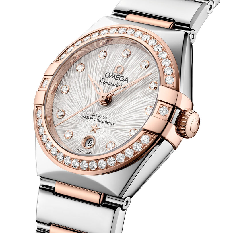 A close-up of an OMEGA Constellation watch featuring a silver dial, diamond hour markers, and a two-tone stainless steel and rose gold bracelet.