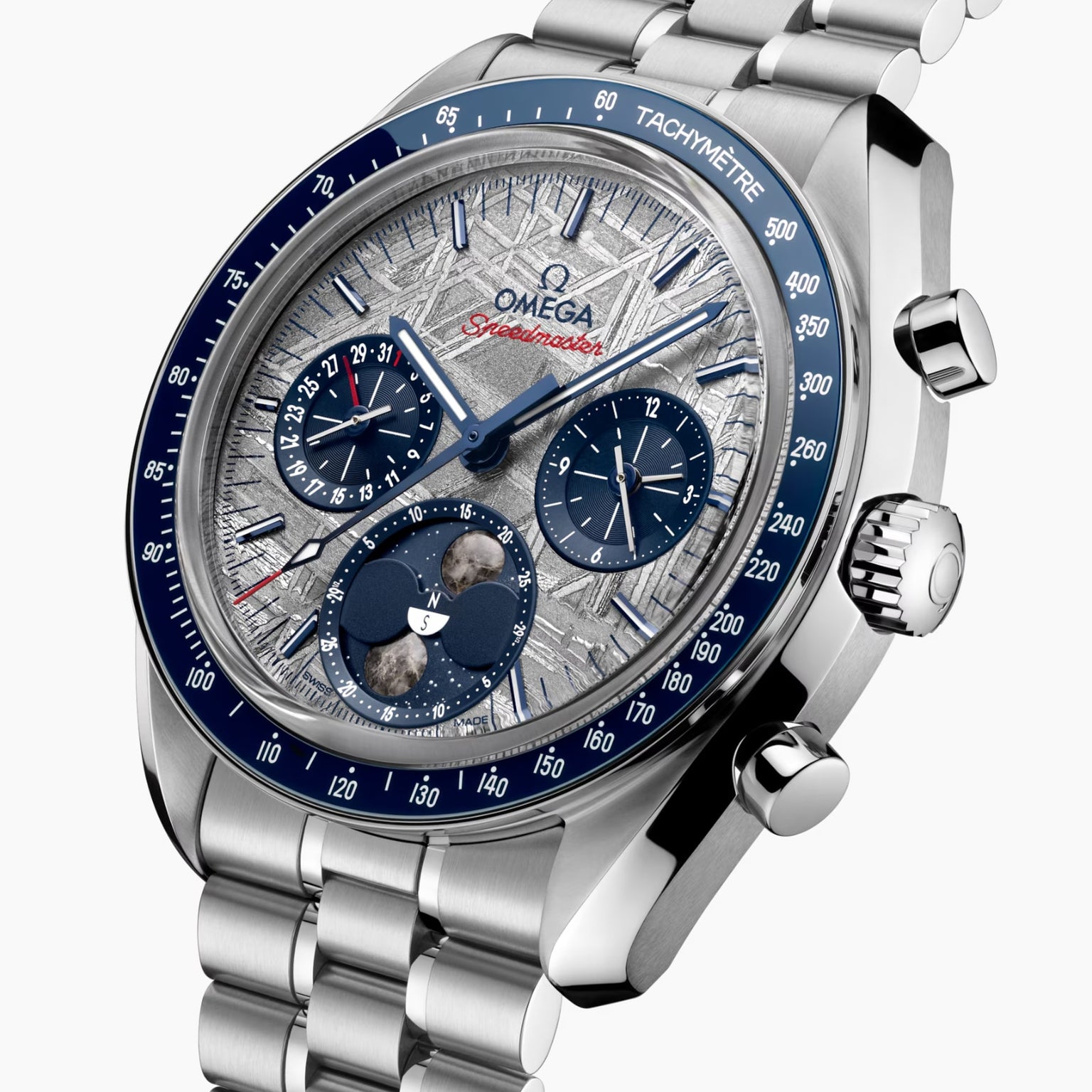 A close-up of the OMEGA Speedmaster Moonphase Meteorite watch featuring a silver and blue face, multiple subdials, OMEGA Co-Axial Master Chronometer movement, and a stainless steel bracelet.
