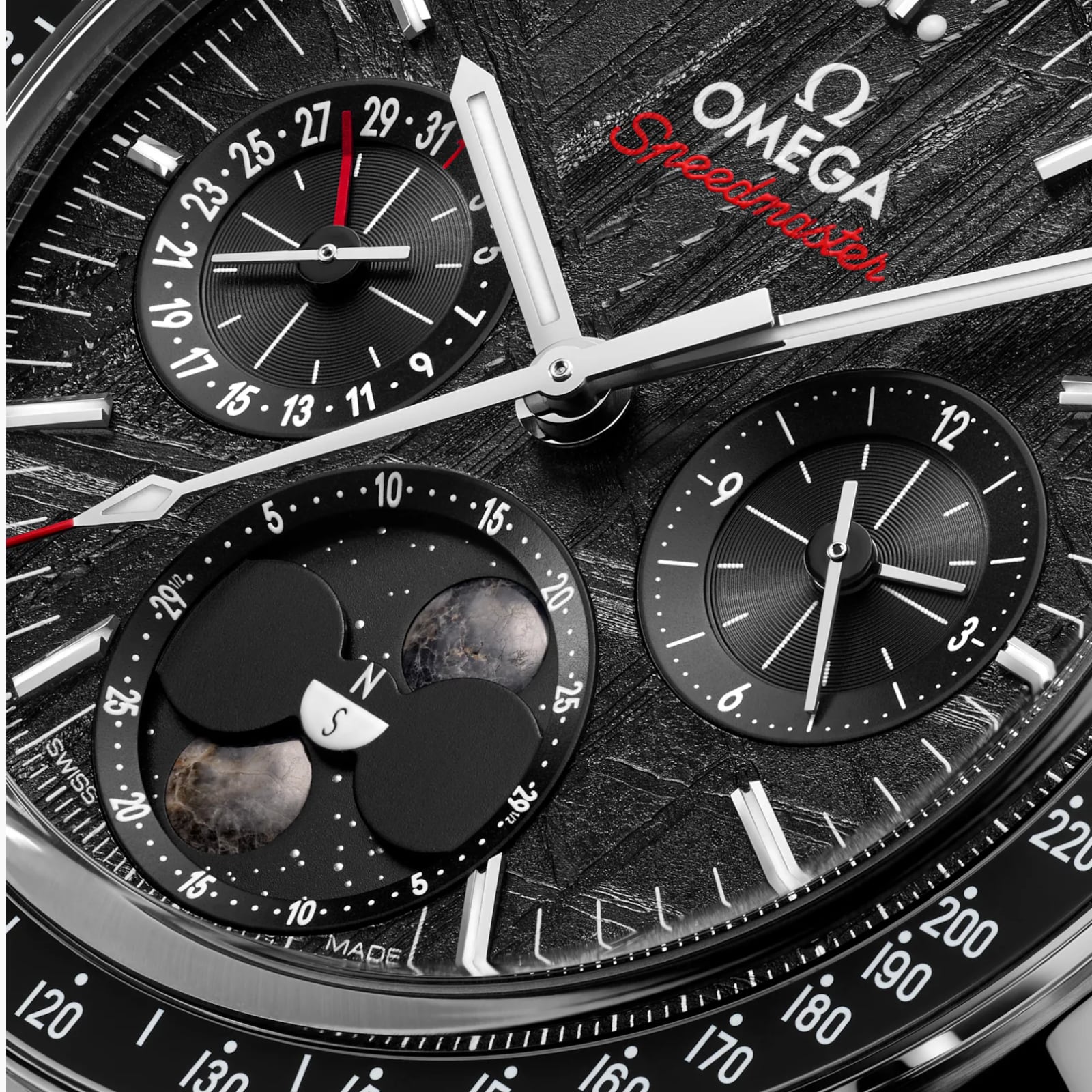 Close-up of the OMEGA Speedmaster Moonphase watch face, showcasing chronograph subdials, date indicators, and a detailed moon phase display inspired by lunar meteorite.