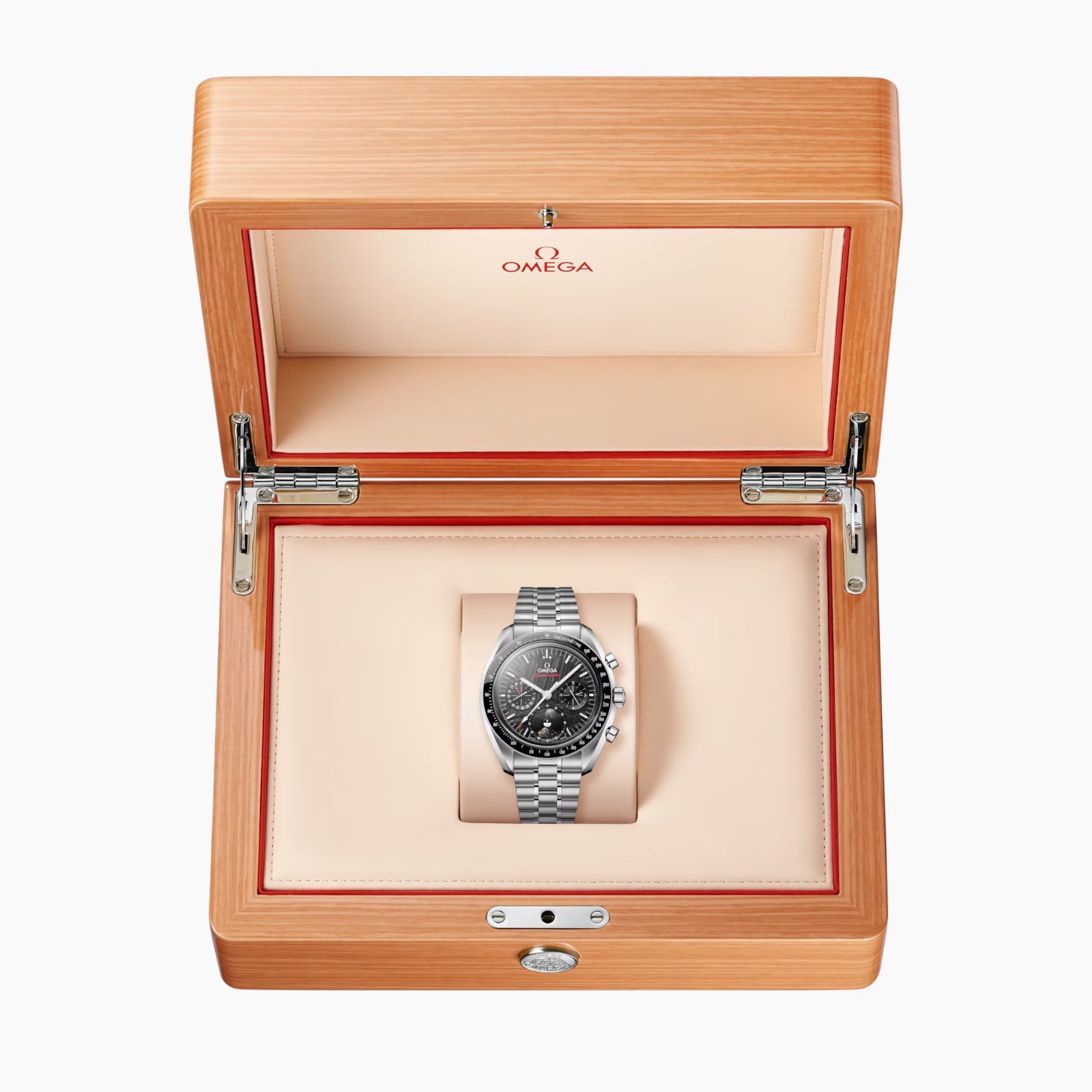 An OMEGA Speedmaster Moonphase wristwatch with a black dial is displayed in an open light wood Omega presentation box featuring a cream and red interior.
