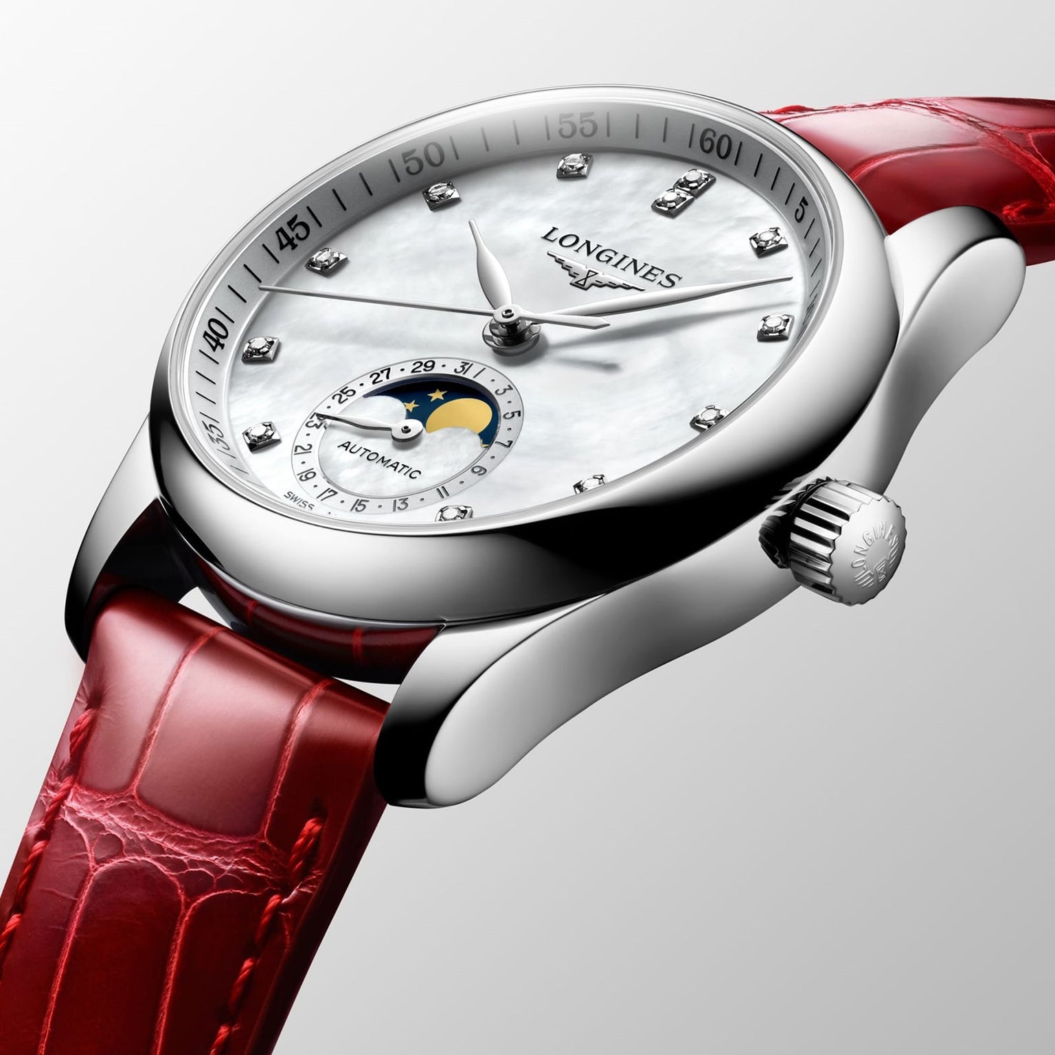 The Longines Master Collection Moonphase is a luxury wristwatch with a red leather strap, silver case, white dial with diamond hour markers, moonphase subdial, and the Longines brand name on the face.