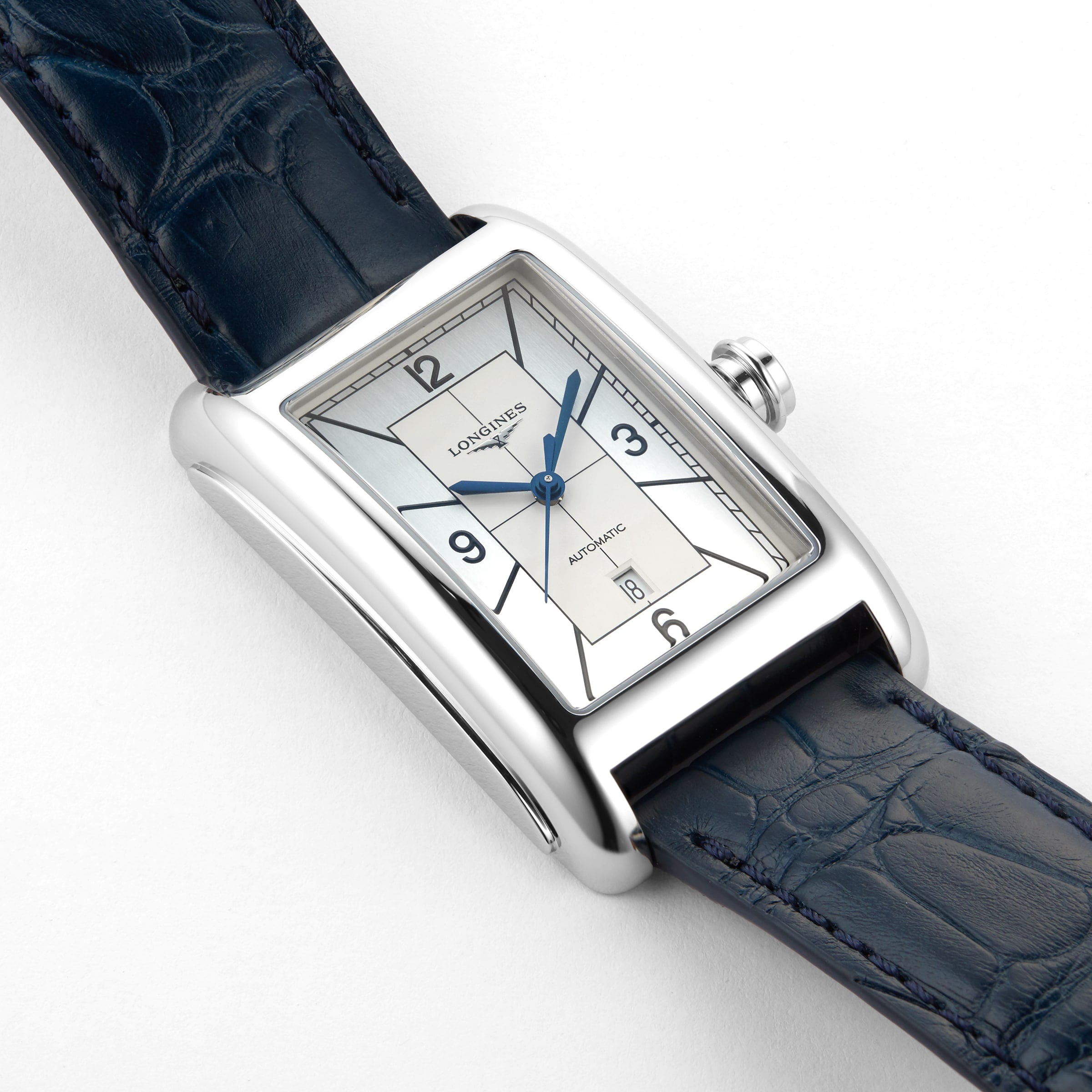 The Longines DolceVita is a rectangular silver wristwatch with a white dial, blue hands, black numerals, date window, dark blue leather strap, and accurate L592 calibre movement.