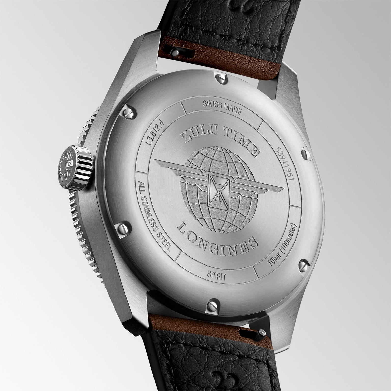 Close-up of the Longines Spirit Zulu Time shows its engraved globe logo and branding on a stainless steel case, paired with a black leather strap.
