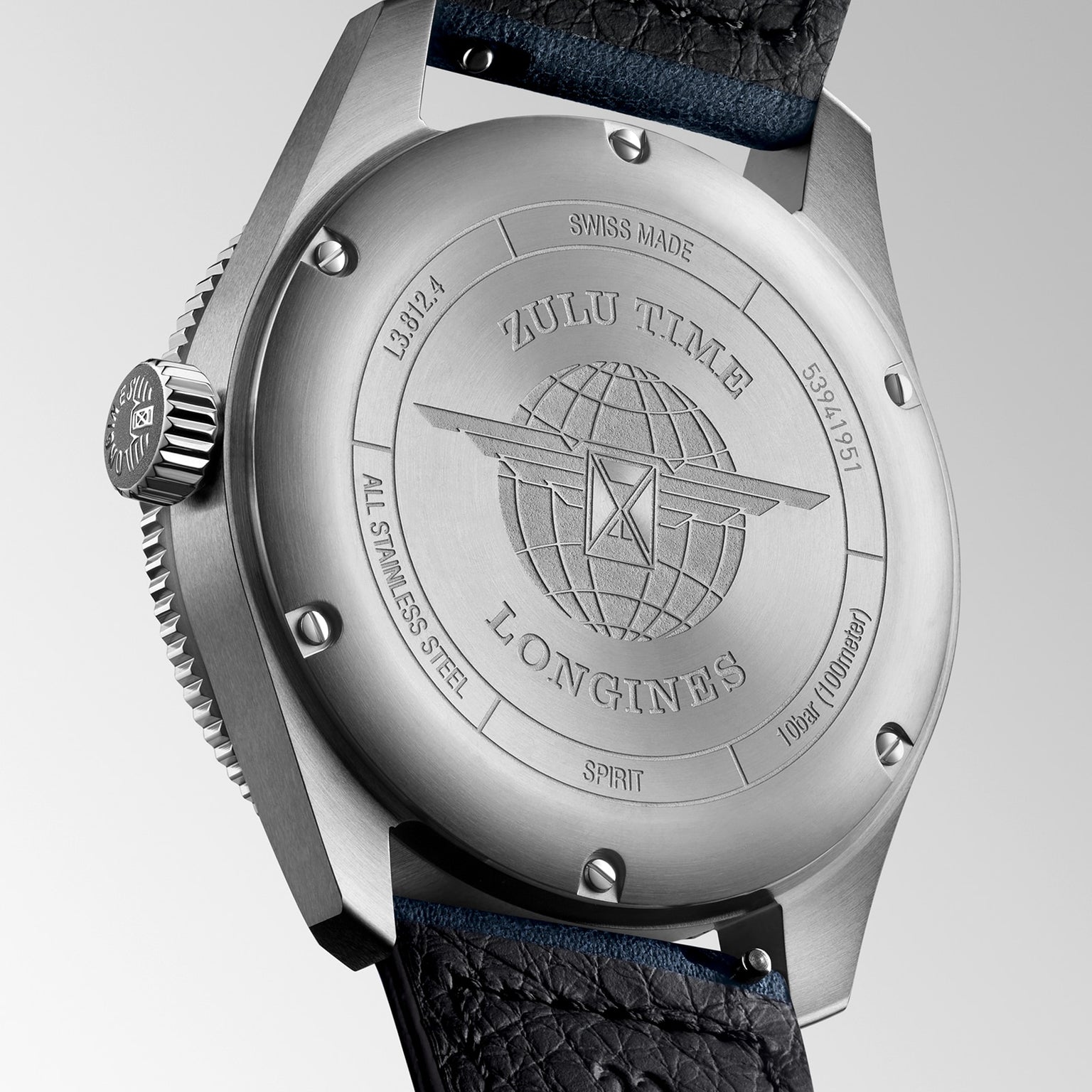 Close-up of the stainless steel case back of the Longines Spirit Zulu Time watch, featuring Zulu Time engraving, a globe with wings logo, serial numbers, and a partially visible black leather strap.