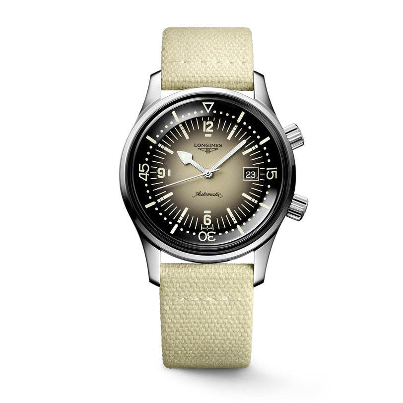 The Longines Legend Diver features a stainless steel case, gradient black-to-beige dial with white markers, two crowns, date at 3 o’clock, light beige fabric strap, and is powered by the precise L888 calibre movement.