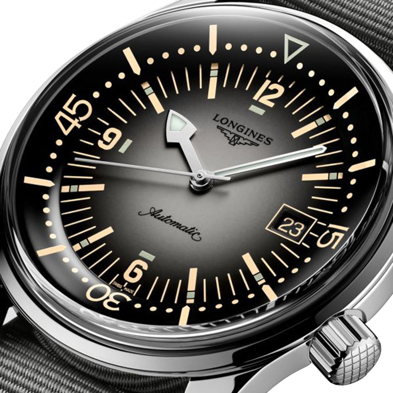 Close-up of the Longines Legend Diver watch with a black dial, bold hour markers, luminous hands, date display, L888 movement, and a grey textile strap.