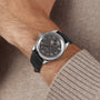 A close-up of a wrist wearing the Longines Master Collection watch, featuring a black leather strap, anthracite dial, and rose gold Arabic numerals, paired with a beige sweater sleeve.