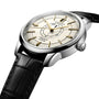 A Longines Conquest Heritage Central Power Reserve wristwatch with a stainless steel case, cream dial, gold markers, black hands, and a black leather strap is photographed at an angle on a white background.