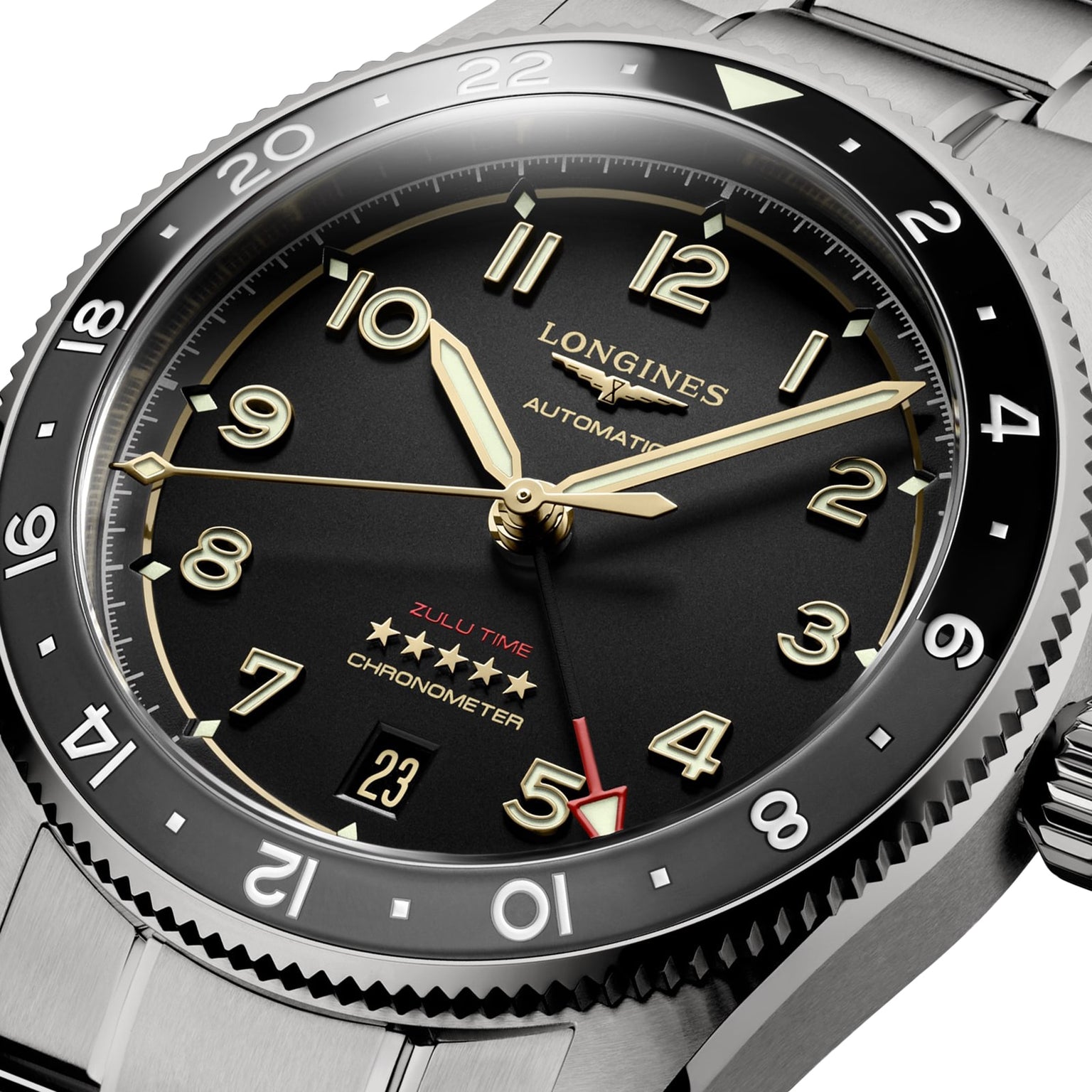 Close-up of the Longines Spirit Zulu Time, an automatic GMT wristwatch featuring a black dial, gold accents, date display, and dual time functionality with a red arrow hand.