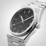 A close-up of the Tissot PRX shows its black dial, silver hour markers, date display, stainless steel bracelet, and precise Swiss quartz movement—highlighting the signature design of Tissot’s PRX watch.