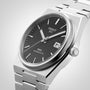Tissot PRX Powermatic 80 wristwatch featuring a black textured dial, date display, and silver metallic bracelet.