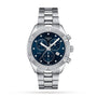 A Tissot PR 100 Sport Chic Chronograph watch in silver, featuring a blue dial and metal bracelet, shown on a white background.