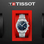A Tissot PR 100 Sport Chic Chronograph with a blue dial is presented in a red box against a black background.