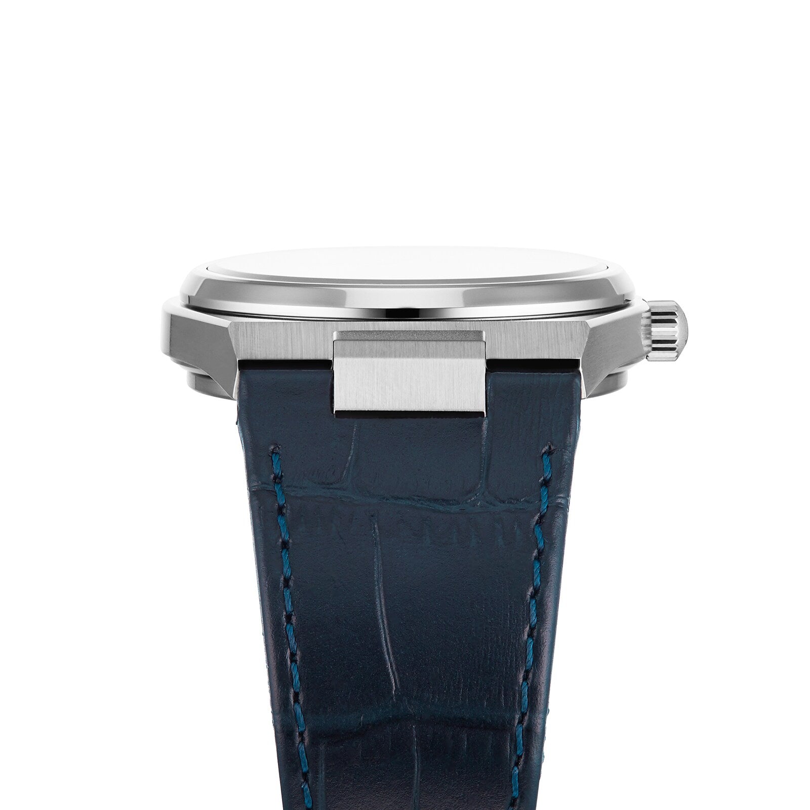 The Tissot PRX is a silver wristwatch with a round case, side crown, and blue leather strap with visible stitching. Inspired by the 1970s, it features reliable Swiss quartz movement and is shown here in a side view.