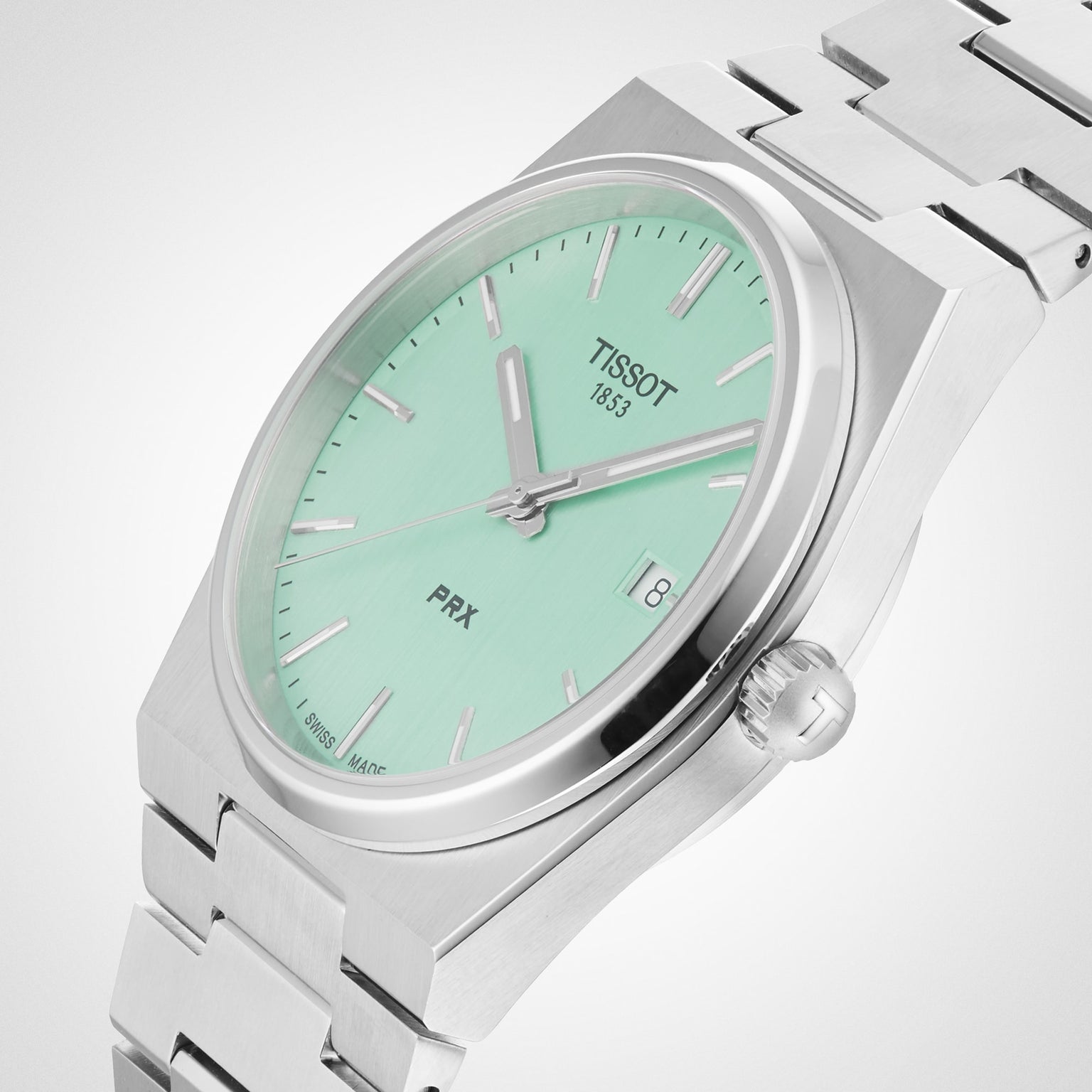 The Tissot PRX features a mint green dial with silver markers and hands, a date window at 3 o’clock, and a stainless steel bracelet for timeless style.