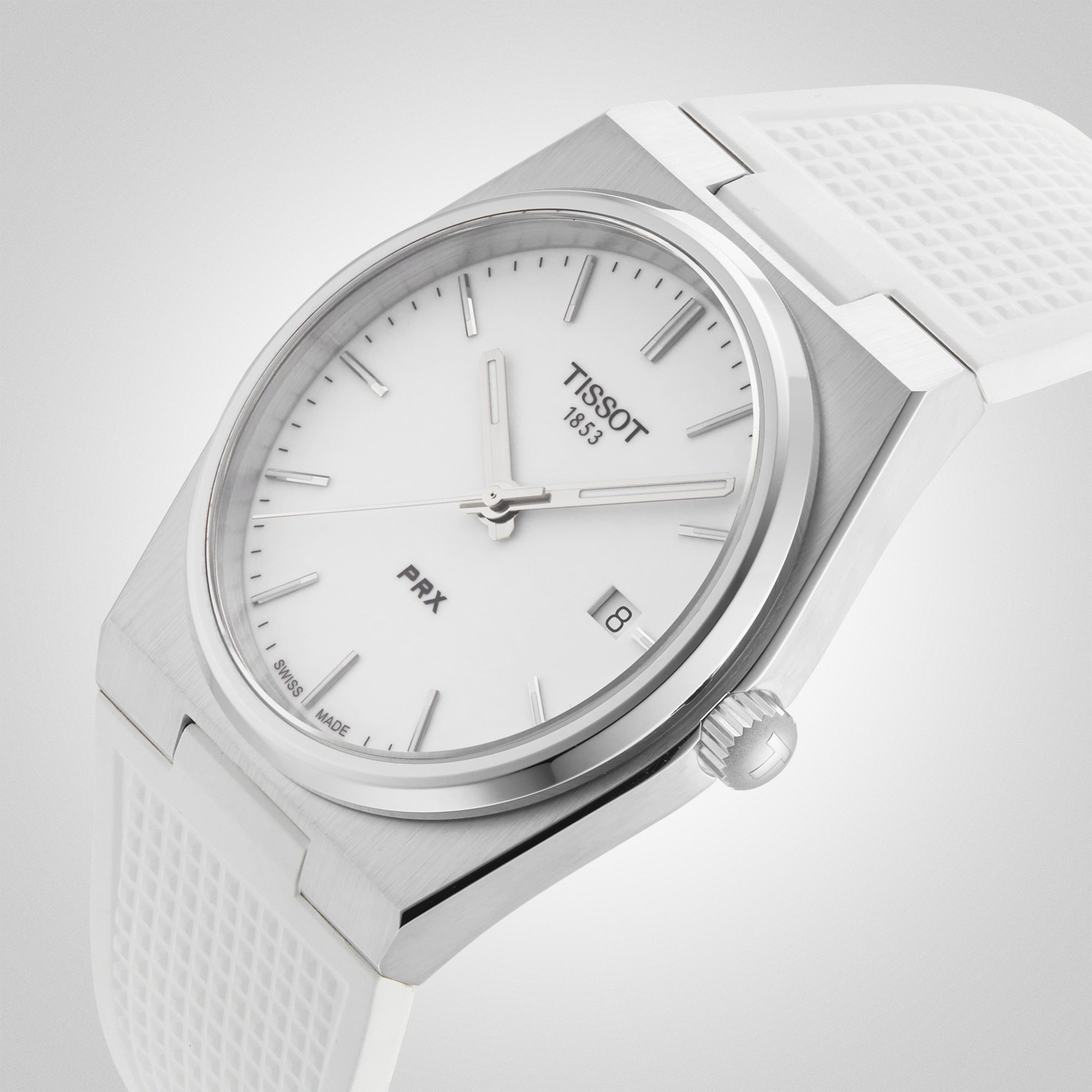 Close-up of the Tissot PRX wristwatch featuring a white dial, silver markers, and a white textured strap.